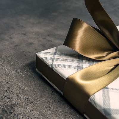 A gift box with a golden ribbon and checker wrap