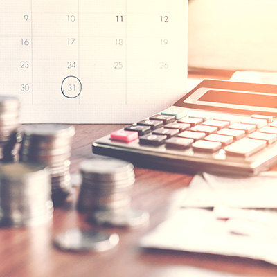 a few stack of coins with a calculator and a calendar circled 31st day