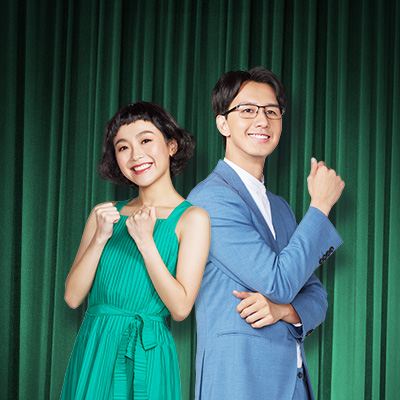 Man in sky blue suit & lady in green dress smiling, image for Standard Chartered Personal Instalment Loan Top Up Service