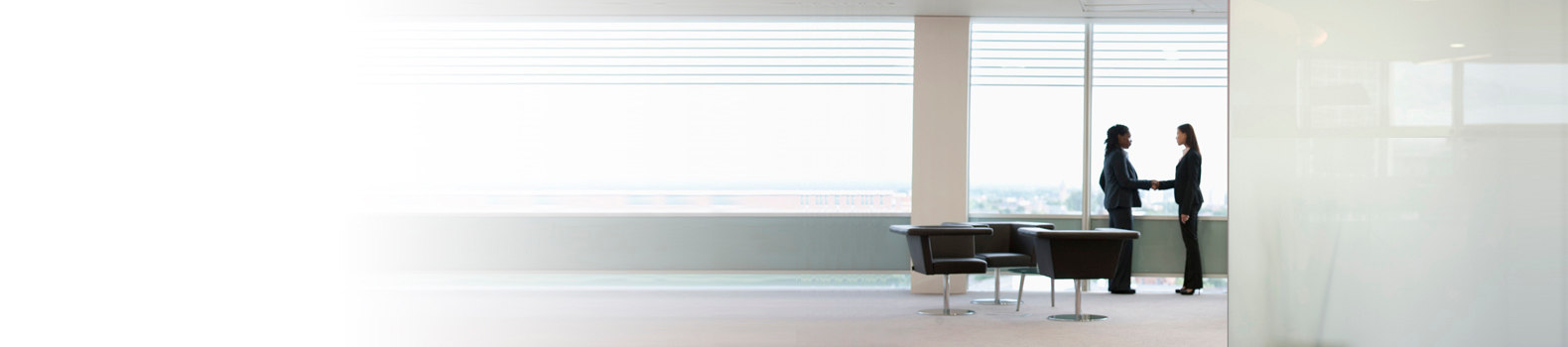 women shaking hands in a conference room for a financial services
