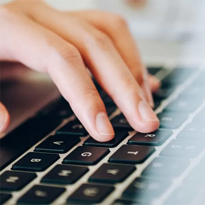 hand typing on a Macbook keyboard