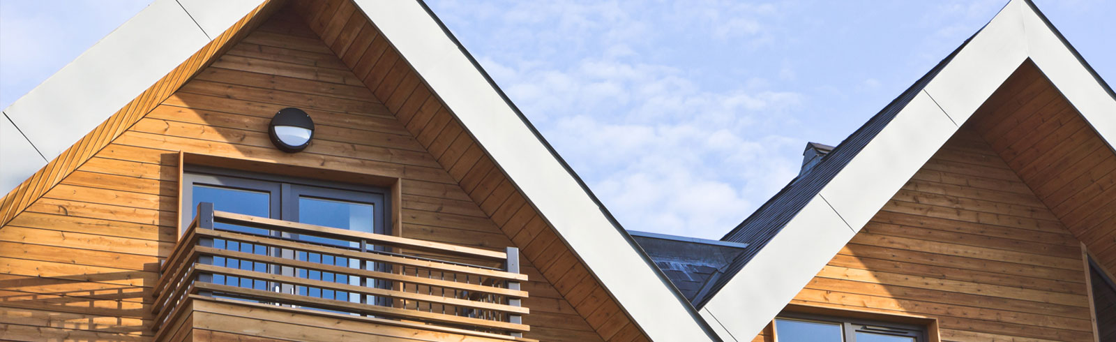 a wooden house with balcony under blue sky